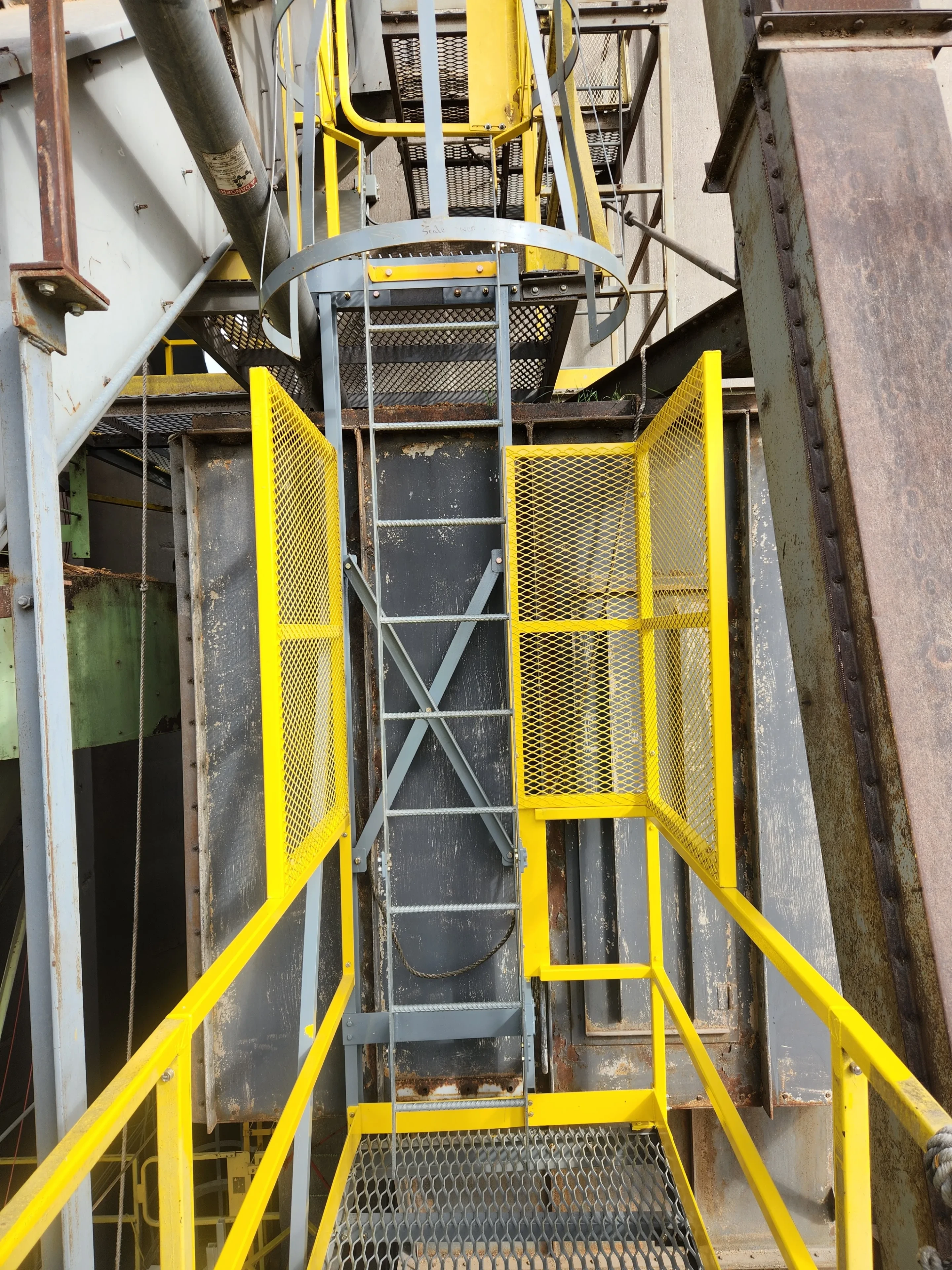 Yellow safety catwalks and ladder access on industrial grain elevator